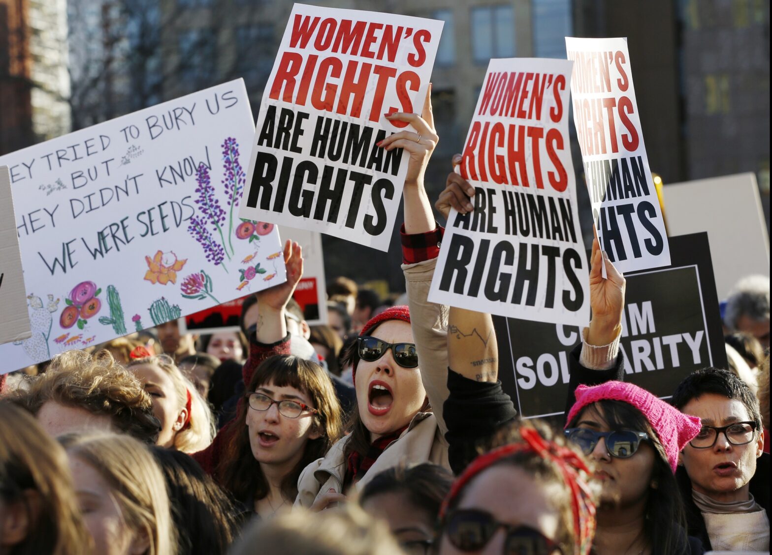 Women chant and hold signs during a rally